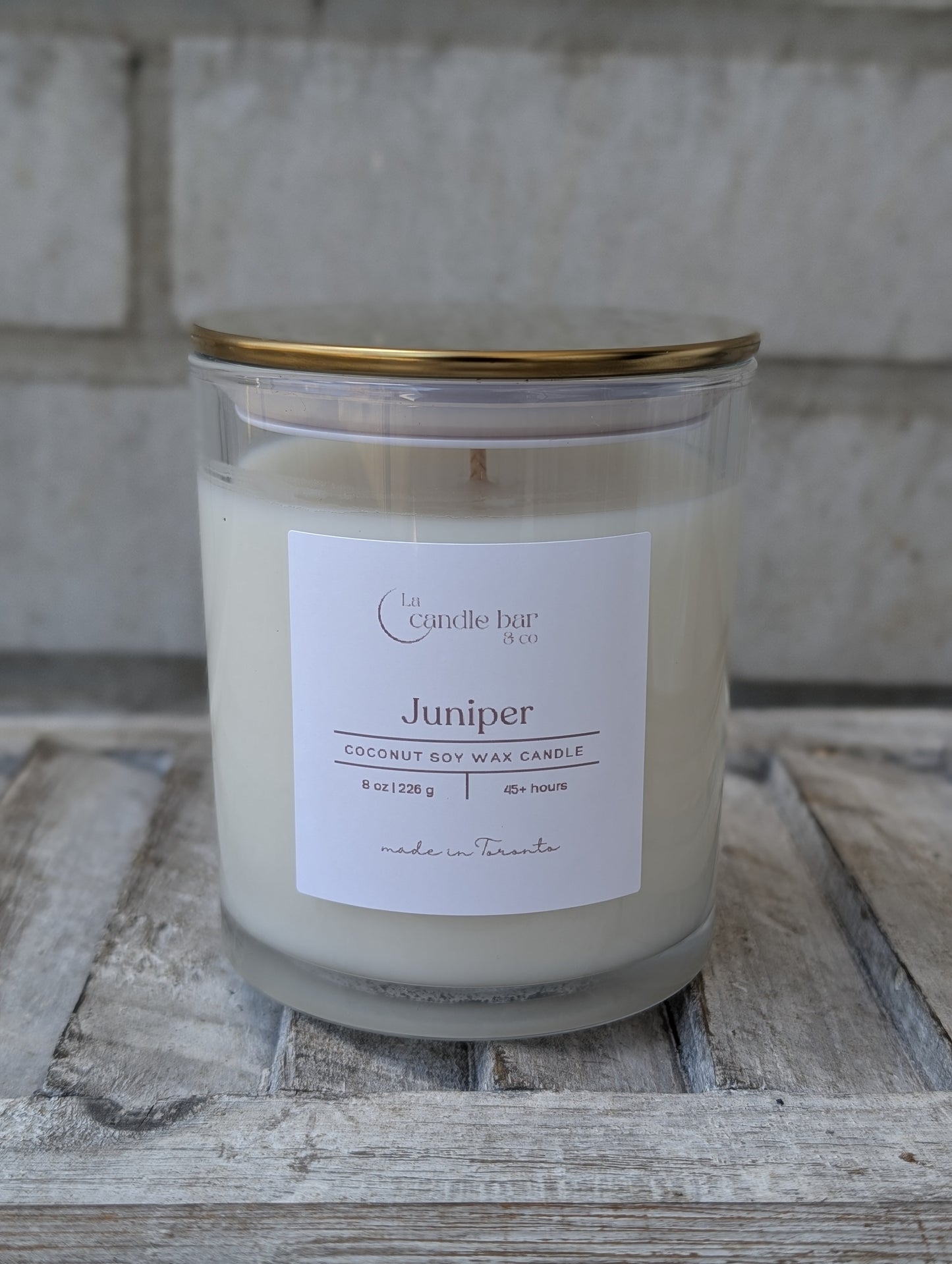 Hand-poured Juniper scented candle in a minimalist jar with gold lid