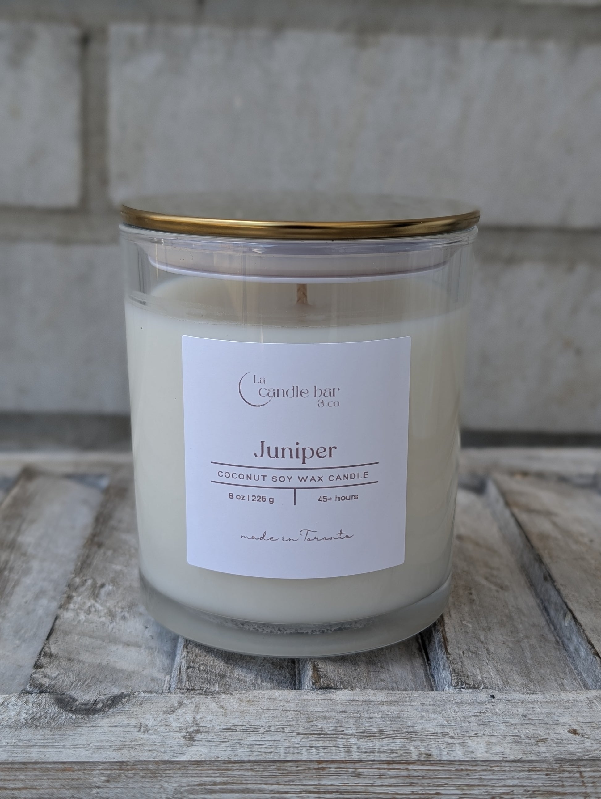 Hand-poured Juniper scented candle in a minimalist jar with gold lid
